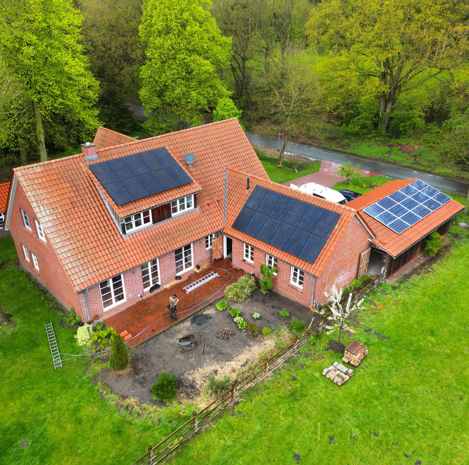 Luftaufnahme eines Backsteinhauses in Norddeutschland mit Photovoltaikanlage auf Satteldach und Anbau, installiert von TRIOSUN